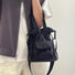 Sleek black mini nylon bucket bag styled for an urban streetwear look.