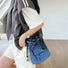 Back perspective of the blue mini nylon drawstring bucket bag on a model.