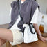 Model wearing the off-white mini nylon bag as a crossbody.
