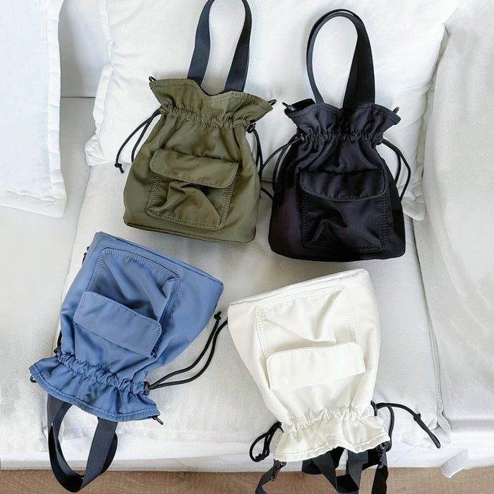 Mini nylon drawstring bucket bag displayed in black, olive green, blue, and off-white.