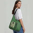 Model wearing a green multi-pocket nylon bag on shoulder.