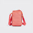 Studio flat lay of the vibrant coral pink multi-way utility bottle bag showcasing its flexible top drawstring closure.