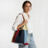 Model styling the red and navy blue crochet knit tote bag on her shoulder.