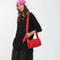 Model carrying a red nylon crossbody bag on her shoulder, ideal for city walks and gifting.