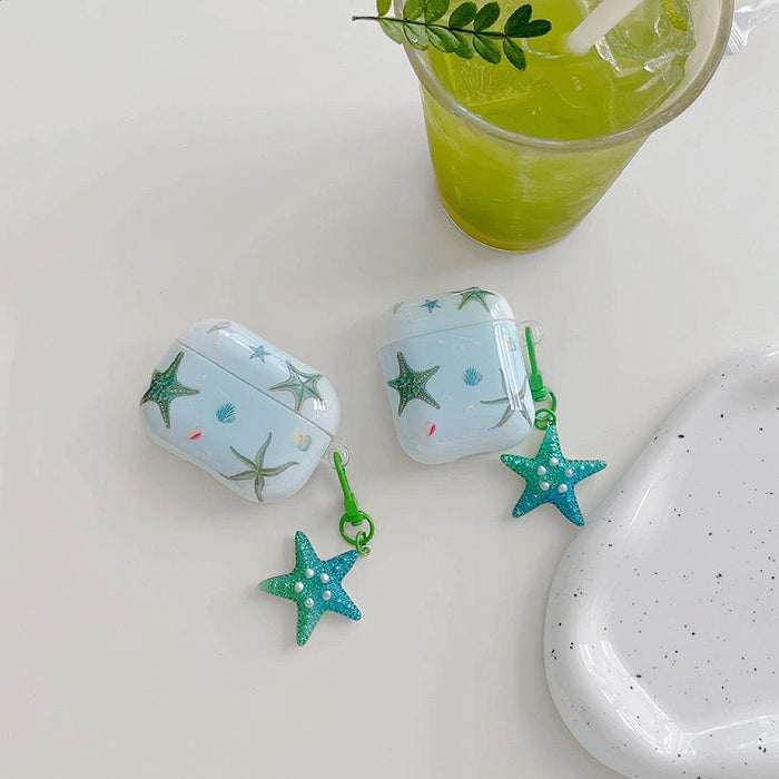 Front view of  two Light blue silicone AirPods cases with green starfish and seashell designs.
