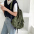 Model wearing olive green waterproof daypack with adjustable backpack straps and functional drawstring closure.