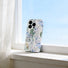Pastel jungle phone case beside the clean window, featuring abstract tropical leaves and geometric patterns.