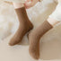 Model wearing a pair of tan Plush Cozy Socks, easy for travel days and daily comfort.