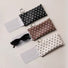 Flat lay of black, brown, and cream white polka dot glasses cases showing attached microfiber lens cloths and metal rings.