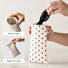 Demonstration of squeezing the metal spring sides to open and close the cream polka dot sunglasses case.