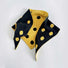 Flatlay view of black and yellow contrast polka dot knit triangle scarf.