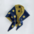 Flatlay view of navy blue and mustard yellow reversible polka dot knit scarf.