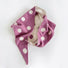 Flatlay view of pink and cream white reversible polka dot knit scarf.