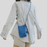 Model carrying a blue Polycolor hanging ball leather bag as crossbody, easy for commuting and weekends.