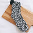Angled view of Pompom Cupcake Socks in black, easy to pack for travel and errands.