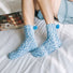 Model wearing a pair of Pompom Cupcake Socks in blue, great for daily wear and lounging.