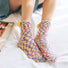 Model wearing a pair of yellow polyester socks, great for casual wear and light workouts.