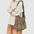 Primal Leopard canvas slouchy bag with adjustable strap, worn crossbody.