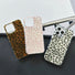 Three silicone leopard print cases in brown, pink, and black on clear backgrounds. Trendy Mob Wife style.