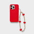 Angled view of Rainbow Heart Phone Charm  hanging on a red phone case, easy to attach to bags and phones.