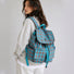 Back view of a model wearing the blue plaid nylon school bag showcasing padded shoulder straps.