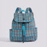 Studio flat lay of the blue and orange retro colorblock plaid nylon backpack showing front buckle flap pockets.