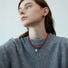 Side view of model styling the red rose dew necklace, sophisticated feminine accessory
