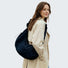 Model carrying a black bag on the shoulder, easy for commuting and weekends.