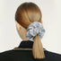Light gray satin scrunchie with rhinestones on a blonde ponytail.
