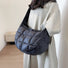 Model carring a black puffy crossbody bag as crossbody; minimalist and functional quilted bag for urban chic.