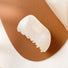 Angled view of Shell hair claw  in white luster, ideal for quick updos and ponytails.