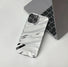 Silver glossy wave case with a reflective fluid design, shown next to a laptop.