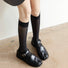 Model wearing black Striped Split-Toe Socks in knee-high, easy to pack for travel and errands.