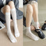 Two models wearing white split-toe socks with silver thread stripe, ideal for everyday outfits and sneakers.