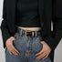Model wearing the black belt with simple square buckle for minimalist style.