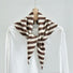 Angled view of the brown and white striped triangle scarf on a hanger, ideal for everyday styling and weekend outings.