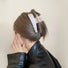 Model wearing a Sleek Curved Hair Clawp in white, ideal for quick updos and ponytails.