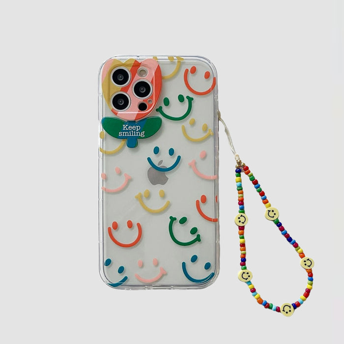 Clear silicone case with colorful smiley faces, Keep Smiling flower charm, and beaded strap.