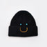 Front view of Smiley Ribbed Knit Beanie in black. Minimalist dark tone paired with a playful smile motif.