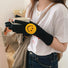Black smiling round face gloves with plush knit texture and smile patch, flat lay; cozy winter accessory.
