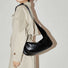 Model carrying a black Soft Leather Baguette Bag on shoulder, easy for commuting and weekends.