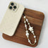 Angled view of a phone case with Starry Pearl Delight Phone Charm, easy to attach to bags and phones.