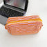 Front view of orange striped knitted makeup bag, easy to pack for trips.