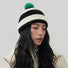 Model wearing the black and white striped beanie with a green pompom.