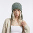 Model wearing the peacock green and olive green striped earflap hat.