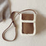 Front view of Brown vegan suede crossbody bag with plush white trim and a long strap, great for everyday carry.