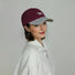 Model wearing burgundy Sun Day Cap. Features premium breathable cotton construction, perfect for active leisure.