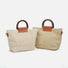 Two raffia straw woven bags, one light beige and one natural, with dark wood grab handles and brown leatherette.