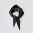 Front view of a black vegan leather triangle scarf tied in a knot on a white background.