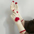 Model wearing sweetheart knitted gloves; heart motif knit for cozy cold-weather styling.